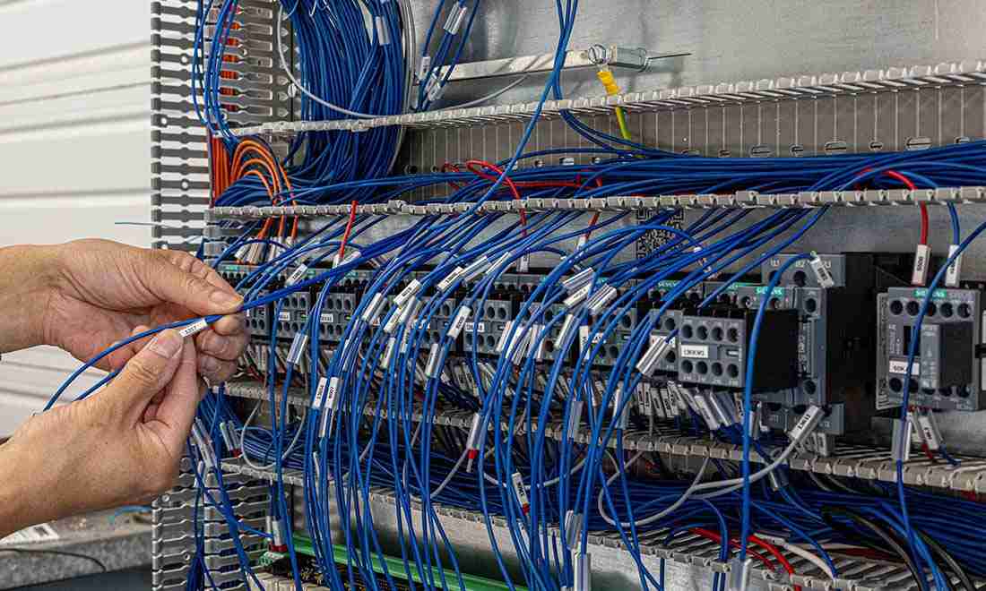 Technician installing structured network cabling and data communication infrastructure in a server cabinet